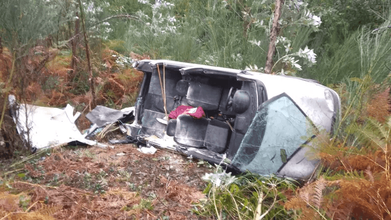 Los bomberos de Arzúa retiran el techo de un coche volcado en Toques para rescatar al conductor